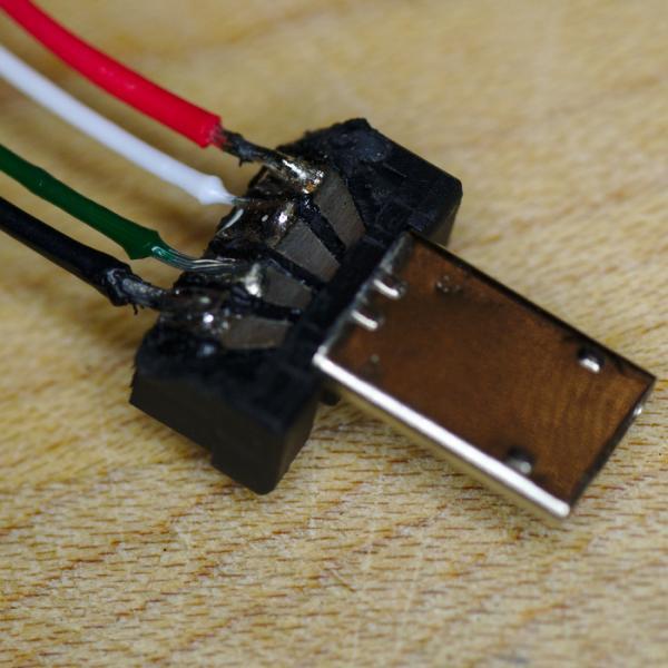 网络摄像头使用的 Micro-USB 插头已经剥掉了线，并直接焊接到触点上。这个插头现在插入到树莓派 Zero 后大约仅高出树莓派 1 厘米。CC BY-SA 4.0
